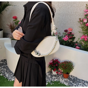 Détail du sac bandoulière blanc demi-lune avec chaîne en perles et cœurs argentés