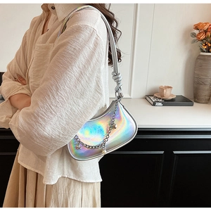 Détail du sac à bandoulière holographique argenté avec chaînes et breloques étoiles