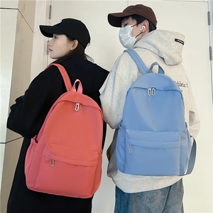 Minimalist nylon school backpack in red and blue, featuring large capacity and side pockets