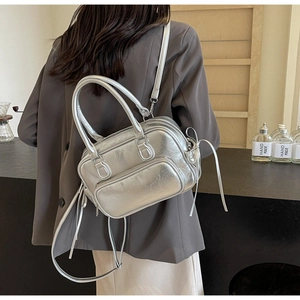 Detail of silver metallic handbag featuring stylish streamers and adjustable straps