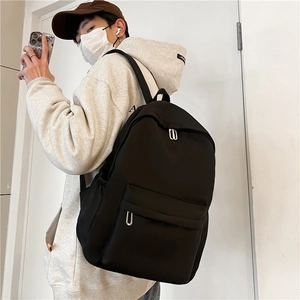 Minimalist black nylon backpack for students with large capacity and silver metal zippers