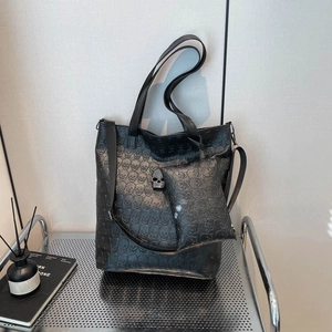 Schwarze geprägte Totenkopf-Einkaufstasche mit kleiner Tasche und Metall-Anhänger auf Regal