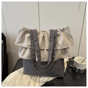 Detail of ruffled tote bag with beige pleated trim and dark grey canvas stitching