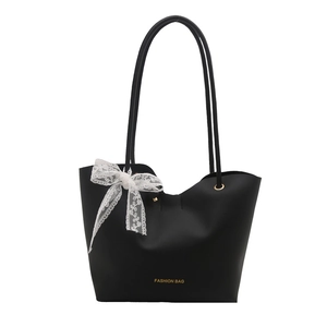 Large black leather tote bag with white lace bow and gold Fashion Bag logo design