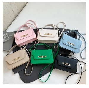 Flat lay of mini crossbody bags in six colors on a grey blazer with golden metal clasp