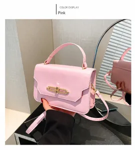 Detailed mirror view of pink crossbody square bag with gold lock and thin strap