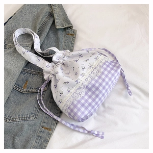 Detail of purple gingham and floral drawstring handbag with delicate white lace trim