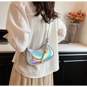 Détail du sac demi-lune laser argenté avec chaîne en métal et pendentif perle sur modèle