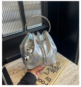 Close-up of holographic bucket bag with round metal handle and chain strap detail