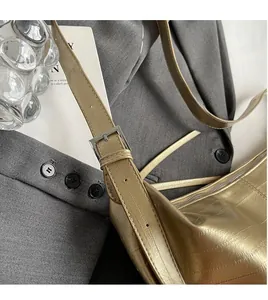 Detailed view of metallic gold faux crocodile leather texture and silver buckle strap