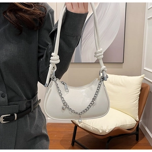 Détail du sac demi-lune blanc avec chaîne argentée et breloques cœur en perles