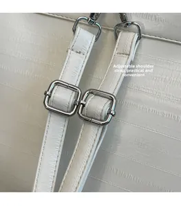 Detail of adjustable white embossed leather straps with polished silver metal buckles