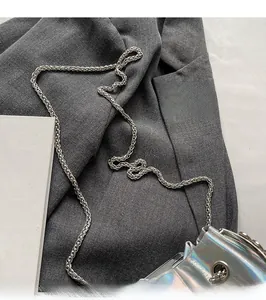 Close-up of the holographic silver bucket bag with its metallic chain shoulder strap