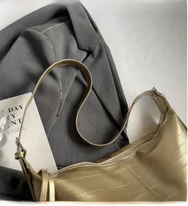 Detail of champagne gold hobo bag with textured leather and adjustable silver buckle