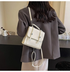 Close-up of cream textured faux crocodile leather backpack with silver buckle details