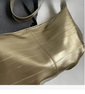 Detail showing the textured metallic gold faux leather and fine embossed patterns on the tote