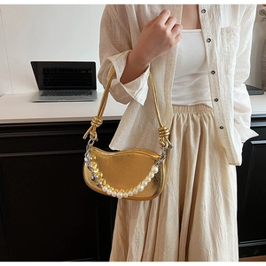 Détail du sac croissant doré avec chaîne perle cœur et bandoulière à poignée nouée