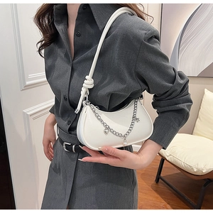 Détail du sac croissant blanc avec chaîne métallique et breloques cœur et perles