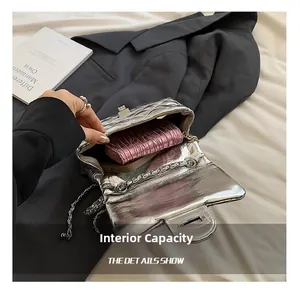 Detailed interior view of silver quilted chain bag with phone and pink wallet