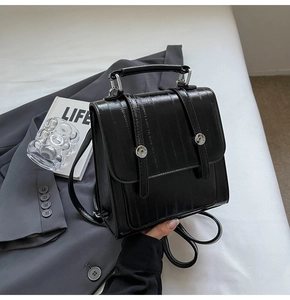 Close-up of matte black PU leather bag with pleated texture and silver metal hardware