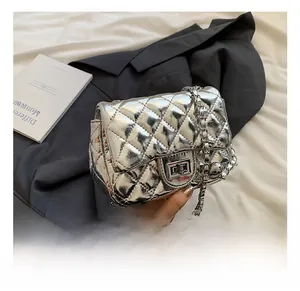 Detailed close-up of quilted silver chain bag with metallic lock and reflective surface