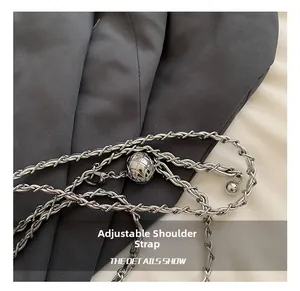 Macro detail of silver metal chain strap with adjustable quilted texture metal ball