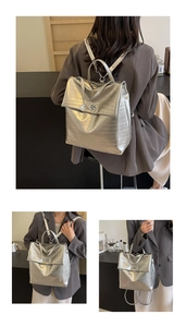 Detail of silver metallic backpack featuring horizontal ribbing and a turn-lock closure