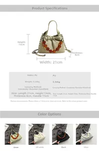 Detail view of ruched cloud bag showing amber beaded handle and metal chain strap dimensions