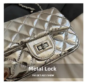 Close-up of a silver quilted chain bag featuring a metallic turn-lock and premium hardware