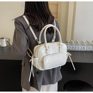 Detail of white glossy synthetic leather backpack with adjustable straps and zip pocket