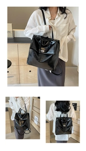 Detail of black glossy faux leather backpack with crocodile texture and silver twist lock