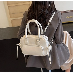 Detail view of cream PU leather backpack with side bow drawstring and dual carry handles