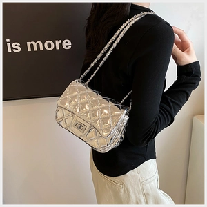 Detail of silver metallic diamond quilted mini bag with a metal chain strap and twist lock