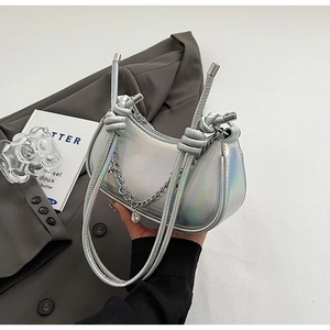 Detail of silver metallic crescent bag with knotted strap, chain and pearl charm detail