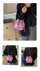 Detail of metallic pink bucket bag showing silver chain strap and drawstring closure