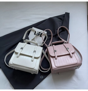 Detail view of vintage white and pink textured PU leather crossbody bags with metal buckles