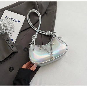 Macro view of holographic silver crescent bag with pearl chain detail and knotted strap
