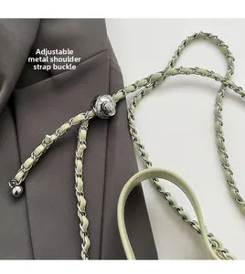 Close-up of adjustable silver ball buckle on mint green leather and chain strap