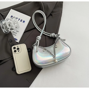 Detailed shot of holographic silver dumpling bag with star charms and knotted handle