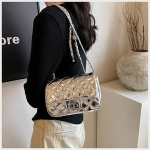 Close-up of silver quilted shoulder bag with metal chain strap and twist lock