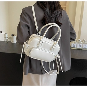 Detail of white glossy PU leather backpack featuring silver hardware and versatile straps