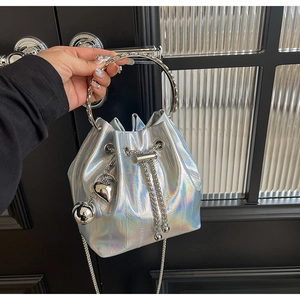Detail of holographic silver bucket bag with metal ring handle and chain strap
