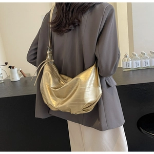 Back view of model wearing a metallic gold crescent bag with textured faux leather