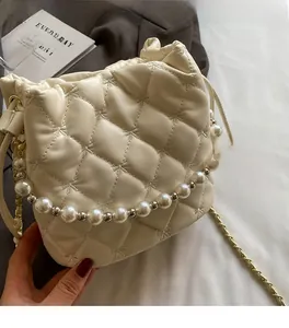 Détail du sac en cuir matelassé crème avec poignée en perles et chaîne dorée