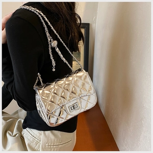 Detail showing silver quilted leather texture and metallic turn-lock closure on chain bag