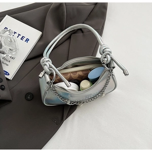 Internal view of silver metallic crossbody bag with chain detail showing storage capacity