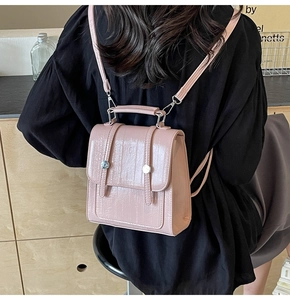 Detail of pink faux crocodile leather backpack with glossy finish and silver hardware