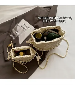 Vue de dessus du sac seau matelassé blanc crème montrant l'espace intérieur et les perles