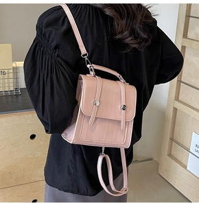 Detail of pink crocodile pattern leather backpack with silver metallic buckle on model