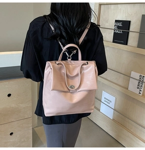 Detailed back view of pink crocodile textured backpack with metal turn-lock and handle